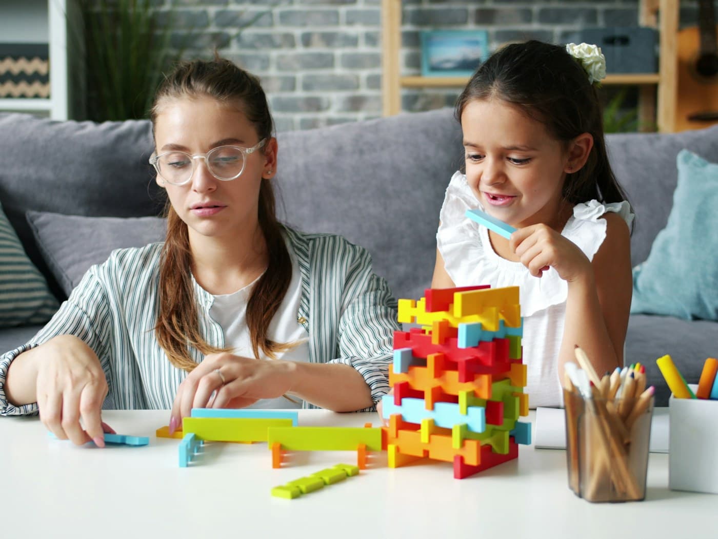 Dos niñas de edad escolar construyendo una torre con bloques de colores